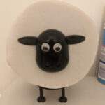 A roll of toilet paper with a sheep head with googly eyes and four adorable little legs.
