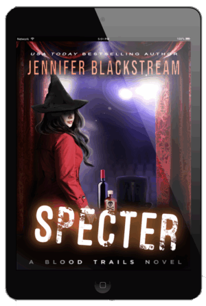 Cover art of Specter, Blood Trails #18, on an ereader, featuring Shade standing in front of a stage holding a bottle of wine, a vial of poison, and a magician's hat.